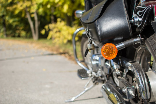 Motorcycle Saddlebag And Turn Signal In Focus. Nature Background.