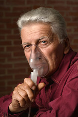 Mature man with inhalator