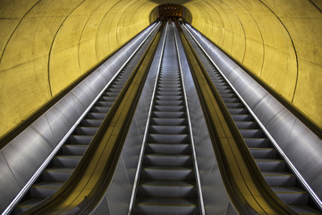 An empty escalator moves through oval tube of light to the Washington D.C. Metrorail commuter...