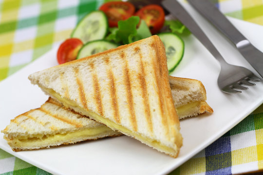 Toasted bread with melted cheese and green side salad
