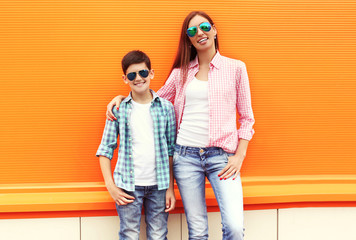 Happy mother and son teenager wearing a checkered shirt and sung
