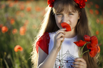 Portrait of a cute little girl  with poppies