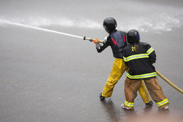 Men dressed in yellow firemen slickers and firehoses have annual Waterfight on July 4, Main Street, Ouray, CO, sponsored by Ouray Fire Department.