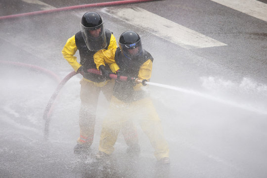 Men dressed in yellow firemen slickers and firehoses have annual Waterfight on July 4, Main Street, Ouray, CO, sponsored by Ouray Fire Department.