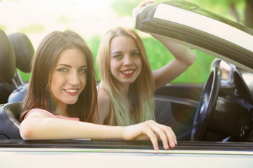 Two girls in cabriolet, outdoors