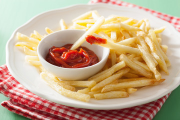 french fries with ketchup over green background