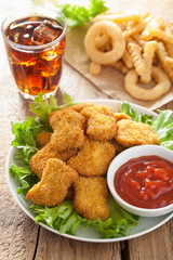 fast food chicken nuggets with ketchup, french fries, cola