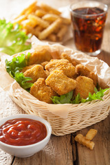 fast food chicken nuggets with ketchup, french fries, cola