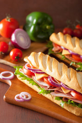 long baguette sandwich with ham cheese tomato lettuce