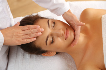 Fototapeta na wymiar Young woman in beauty spa salon enjoying head massage