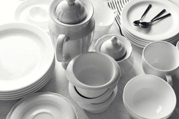 Set of white ceramics dishes on wooden table, closeup