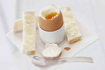 Fresh boiled egg with bread and butter to dip in.