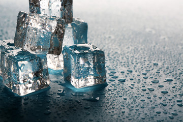 Melting ice cubes with drops around, close up