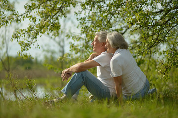 Senior couple sitting near lake