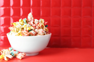 Sweet colourful popcorn on red background