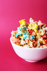 Sweet colourful popcorn on pink background