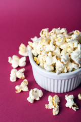 Salted popcorn on pink background