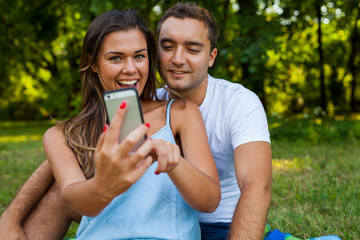 Pretty girl is showing something on smartphone to her boyfriend.
