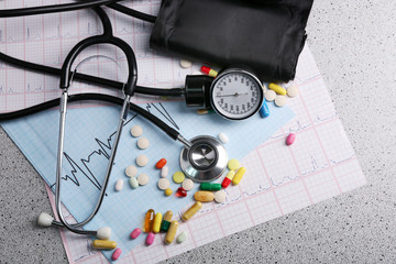 Blood pressure meter, pills and stethoscope, on grey background