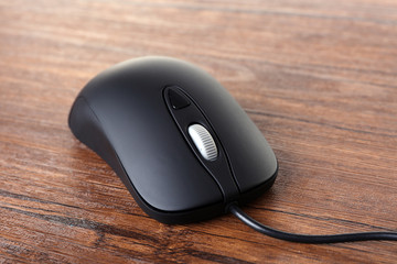 Computer mouse with cord on wooden background
