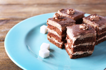Sweet chocolate cake on blue plate on wooden table