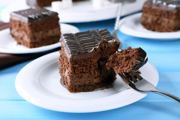 Served table with chocolate cake on blue background close-up