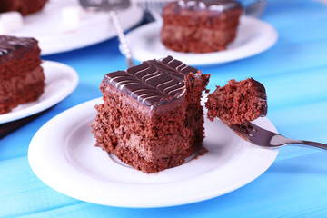 Served table with chocolate cake on blue background close-up