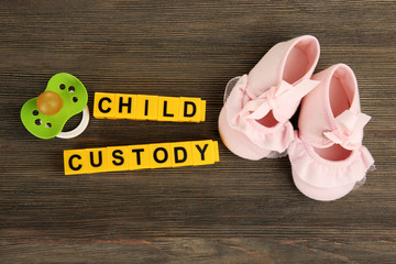 Baby's booties, dummy and blocks regarding child-custody and family-law concept