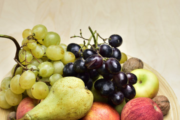 Autumn fruits on a wooden plate