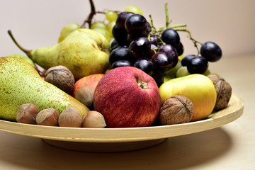 Autumn fruits on a wooden plate