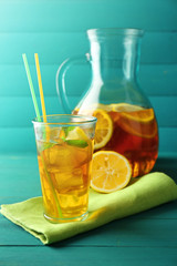Iced tea with lemon on  color wooden background