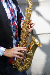 Obraz na płótnie Canvas Saxophonist plays jazz outdoors, close up