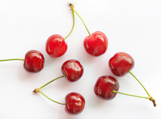 Obraz na płótnie Canvas Close-up of seven fresh organic cherries on white background.