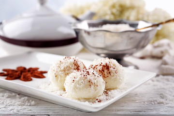 Homemade coco sweets on plate, on light background