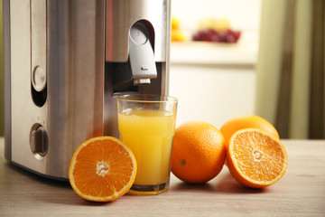 Juicer and orange juice on kitchen table