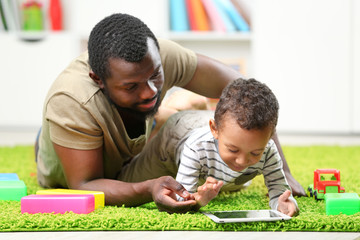 Obraz premium Father and son paying in the children room