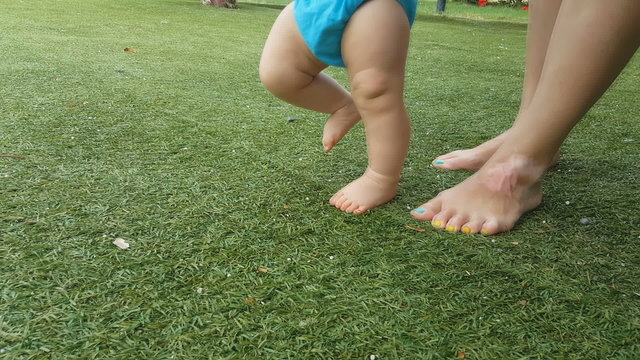 Baby first steps on grass, close-up