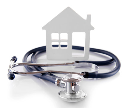 Concept of family medicine - white mini house and stethoscope isolated on white background