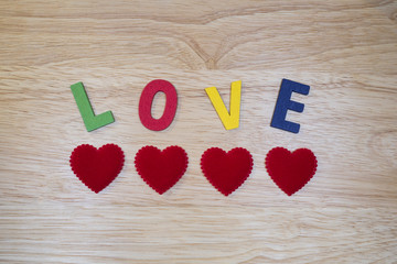 Word Love 3 - Colorful words "Love" made from wooden letters on wood background (Valentines day)