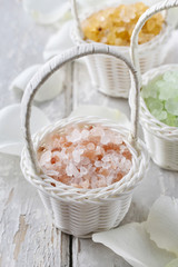 Sea salt in wicker baskets among white rose petals