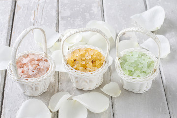 Sea salt in wicker baskets among white rose petals