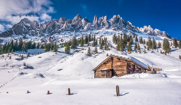 Idyllic winter wonderland scenery with traditional mountain chalet in the Alps