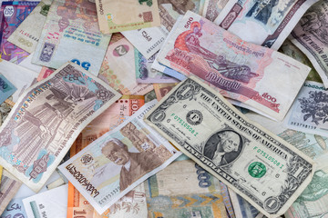 Many banknotes of different countries scattered on the table