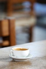 Cup of coffee in the table on defocused background