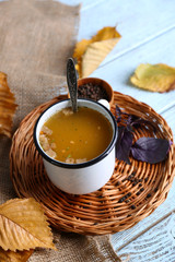 Mug of soup on wicker mat on a table