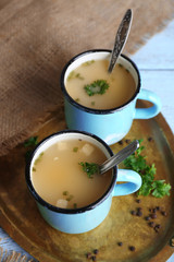 Mugs of soup on metal tray on a table