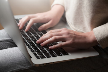 Fototapeta na wymiar woman hands using laptop at office desk, with copyspace in dark