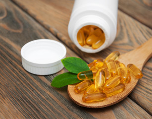 fish oil capsules in a spoon