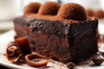 Slice of chocolate cake with a truffle on plate closeup