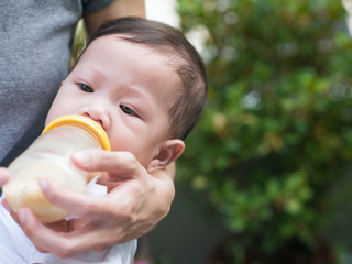 Asian mother feeding bottle her baby.